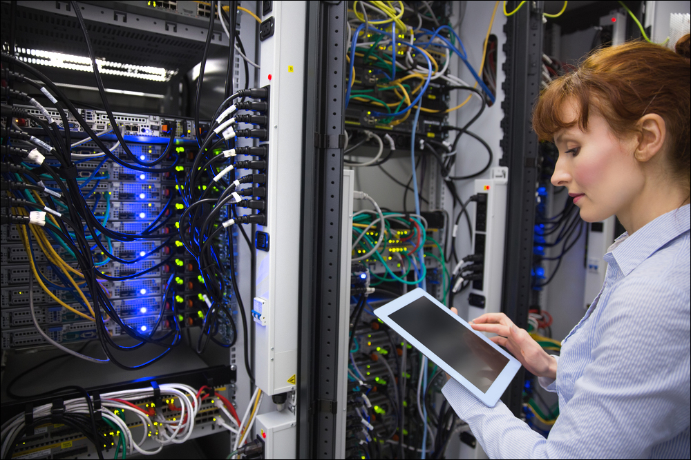 Technician analysing server in large data center